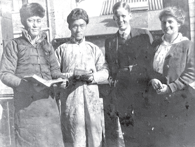 Two Chinese men with books in their hands stand next to two white people.