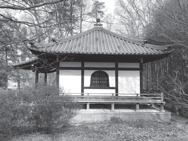 Square building with pagoda roof surrounded by trees.