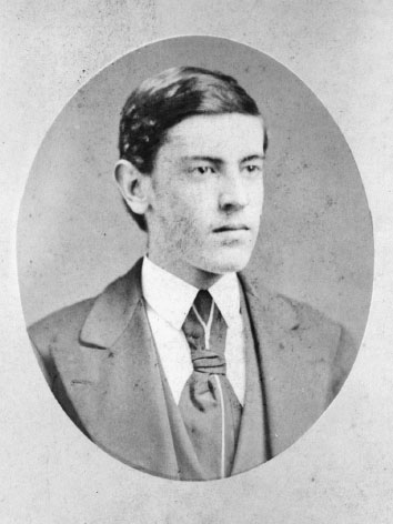 A headshot of man in a suit and tie looking off to the right.