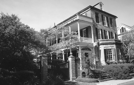 A three-story brick house sits in three-quarter profile.