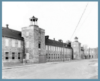 A long, two-story brick building lined with windows.