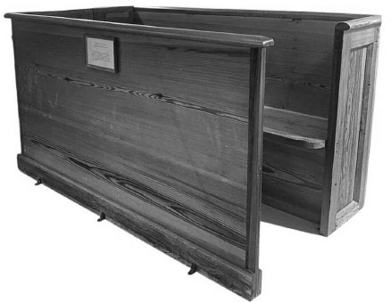 An enclosed wooden family pew with a plaque.
