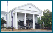 A large, two-story house with columns and curved staircases.